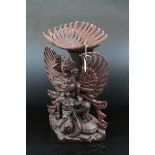 A contemporary Asian wooden carving of a goddess riding dragons...