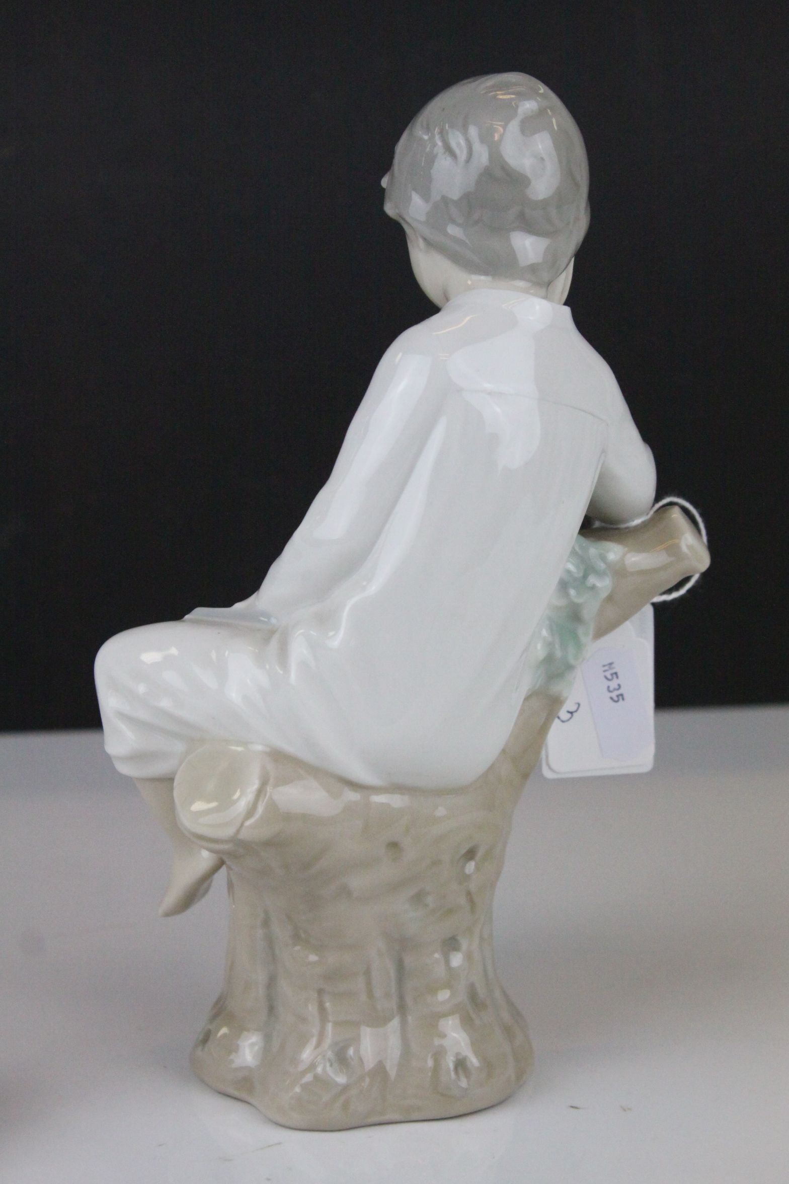 Two Lladro Figures - Boy with Book sat on a Tree, 21cms high and Baby sleeping on a Pillow, 10cms - Image 3 of 9