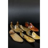 Two pairs of antique wooden shoe trees together with two singles.