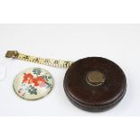 Vintage leather tape measure (af) and Domed glass paperweight with flower decoration