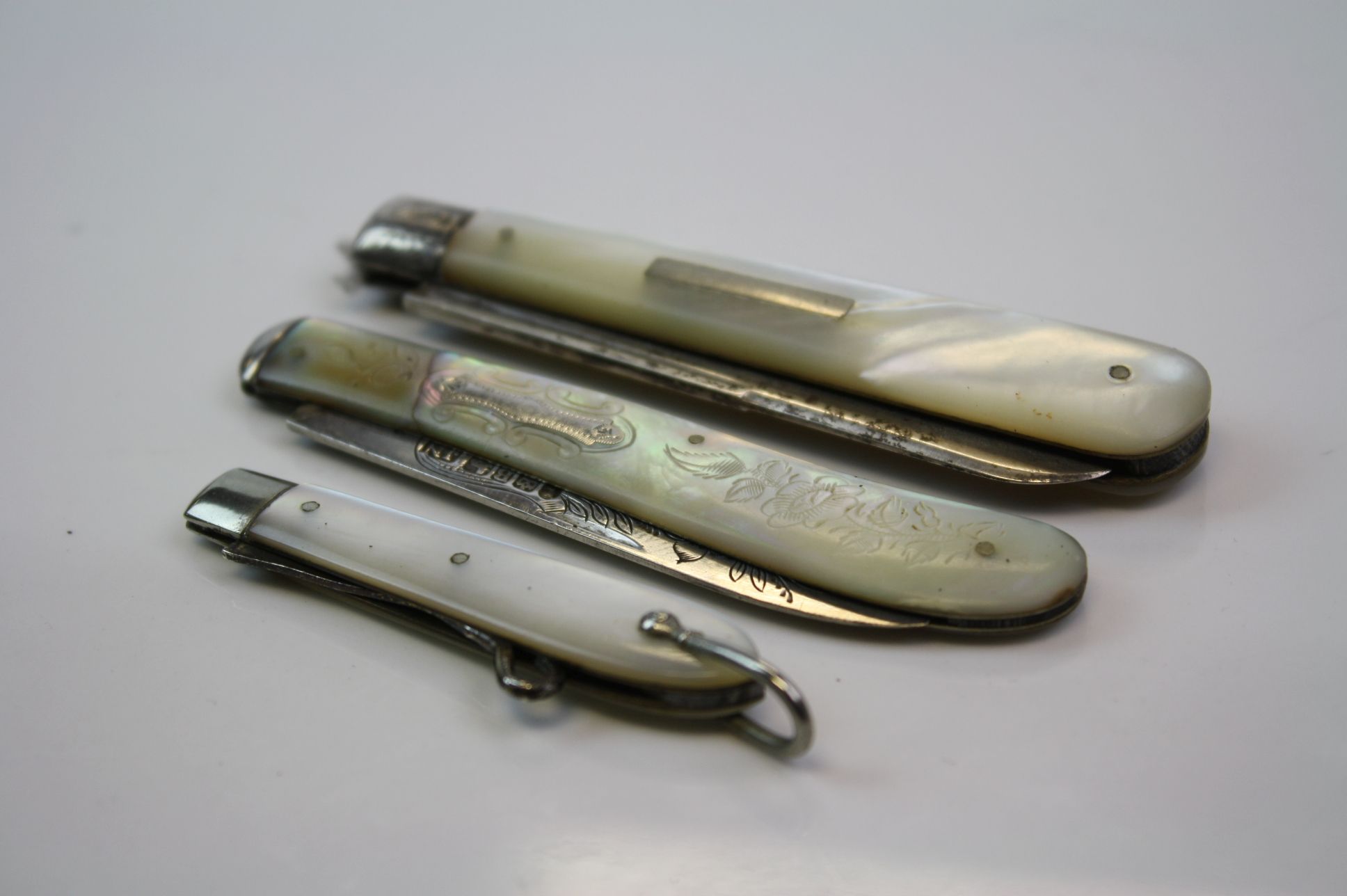 Two fully hallmarked sterling silver & mother of pearl folding fruit knives together with a