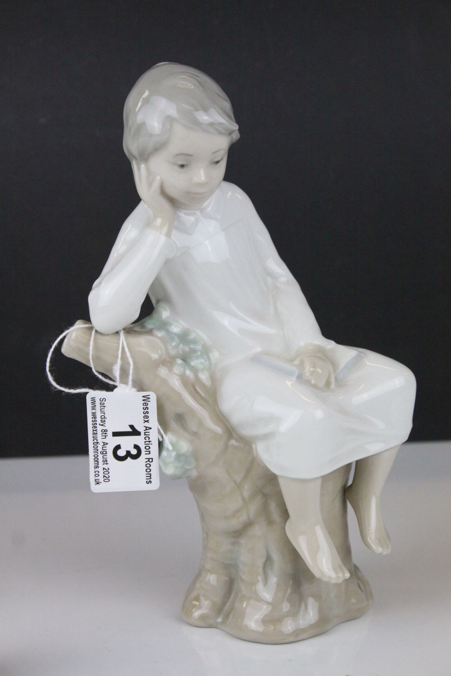 Two Lladro Figures - Boy with Book sat on a Tree, 21cms high and Baby sleeping on a Pillow, 10cms - Image 2 of 9