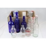 A quantity of vintage glass bottles to include milk a blue and white hexaganol vase and glass bowl.