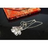 White Metal Pendant with attached Leaves together with a Necklace contained within a embroidered