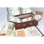 A suitcase containing a quantity of first day covers stamps some in albums.