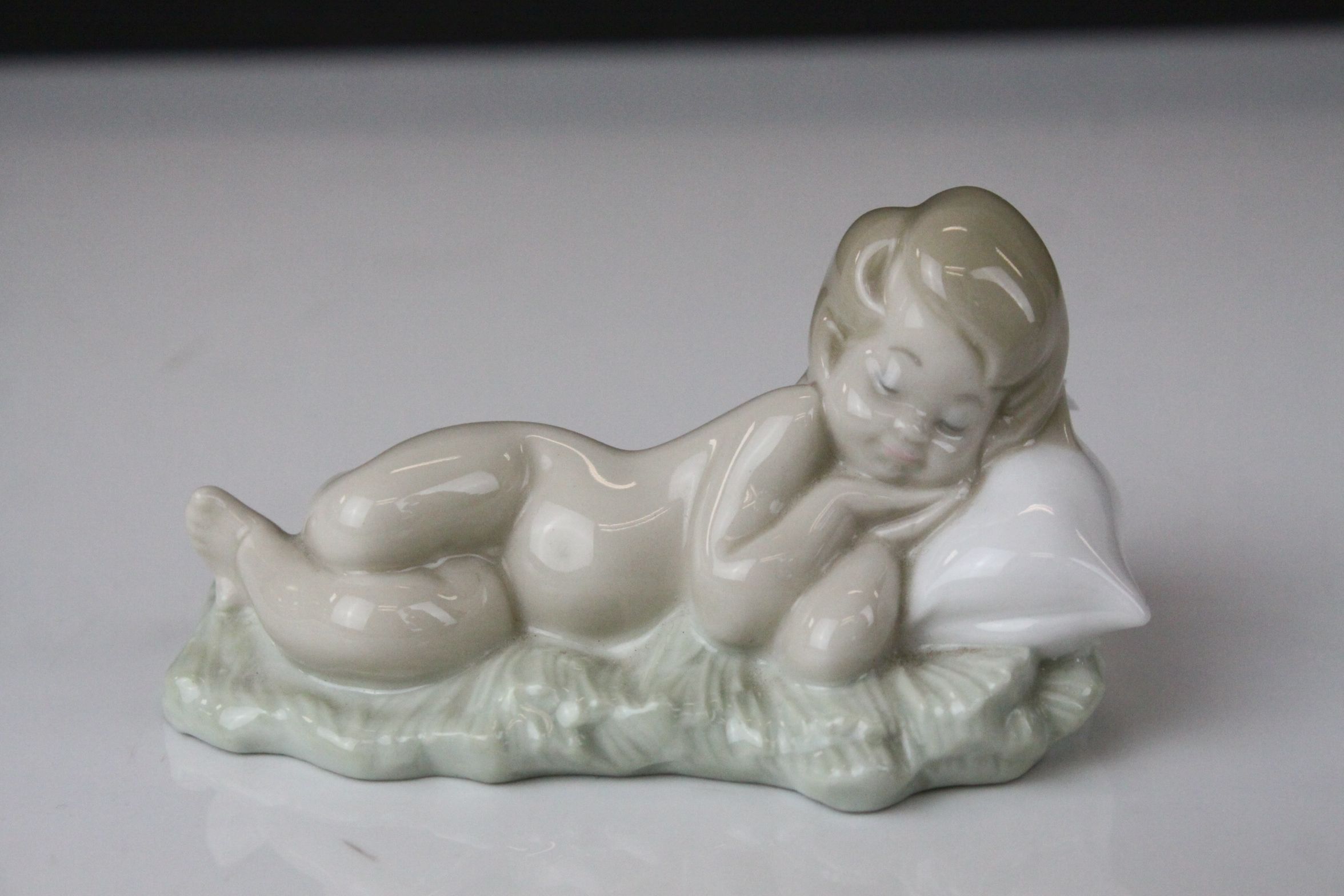 Two Lladro Figures - Boy with Book sat on a Tree, 21cms high and Baby sleeping on a Pillow, 10cms - Image 5 of 9