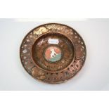 An arts & Crafts copper pin dish with pierced decorative rim and enamel dog to centre.