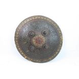 An Antique Eastern Leather Ornately Decorated Shield With Hand Grips To Reverse.