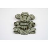 A World War Two British Military Economy Plastic Cap Badge To The Welsh Regiment With Twin Metal