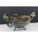 A bronze bowl decorated to the edge with birds raised on three legs.