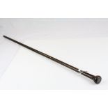 An antique rosewood walking stick with silver coin mounted into the knop