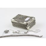 A white metal trinket box with a quantity of jewellery
