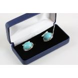 A pair of silver and turquoise set cufflinks