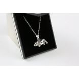 A silver pendant necklace with articulated bear