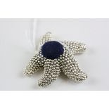 A silver pin cushion in the form of a starfish