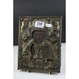 An antique Russian religious icon painted to wooden panel with decorative brass overlay.