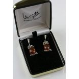 A pair of silver amber style drop earrings in the form of owl's