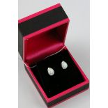 A pair of silver and opal pear shaped stud earrings