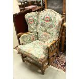 Mid 20th century Ercol Oak Wingback Armchair with brightly floral patterned cushion seats