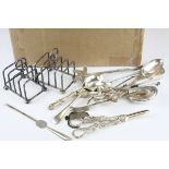 A box of silver plated items to include toast racks, spoons and tongs together with a hallmarked