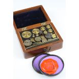 A cased set of brass weights together with a boxed wax seal.
