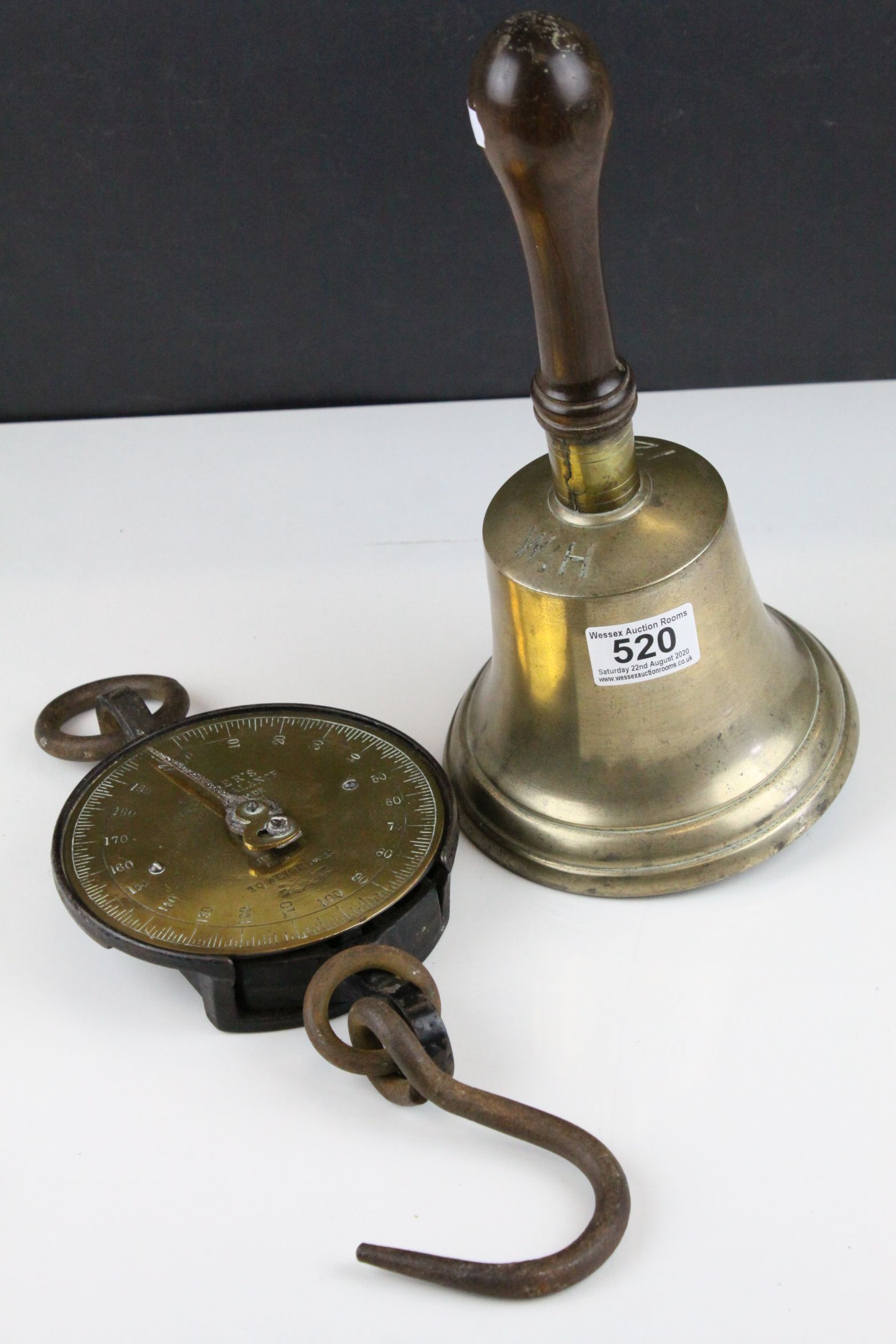 a large brass antique hand bell marked 12 W. H with wooden handle and a 200 lb Salters spring