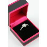 A silver heart shaped ring set with CZ's and central opal
