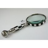 A large hand held magnifying glass with checkerboard pattern