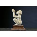 A carved ivory figure drinking from a bowl, h: 5 cms