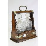 Late 19th / Early 20th century Oak Two Bottle Tantalus with Silver Plated Mounts (matching decanters