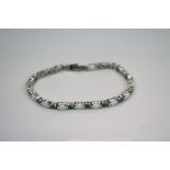 A silver opal and emerald line bracelet