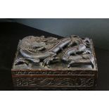 A 19th century Chinese carved wooden cigar box, the hinged lid decorated in high relief with the a