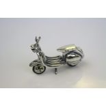 A silver figure of a vespa scooter