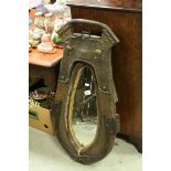 An antique leather horse collar wall mirror with studded and metal decoration.