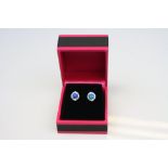 A pair of silver stud earrings set with opal and CZs