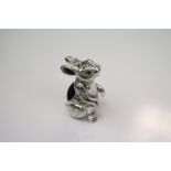 A silver pincushion in the form of a rabbit