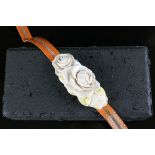 A carved ivory belt buckle in the form of roses, signed, on a yellow metal mount stamped "K18", 9.