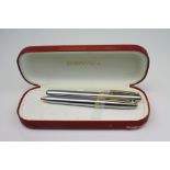 A Sheaffer ballpoint and fountain pen set within red presentation case.