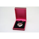 A silver necklace with heart shaped locket
