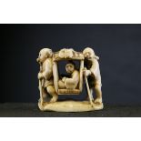 A 19th century ivory netsuke of a man being carried in a sedan chair, signed, each attendant
