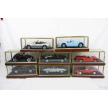 Eight cased 1:18 scale diecast model classic cars to include Ferrari, VW, MG etc, models fixed to