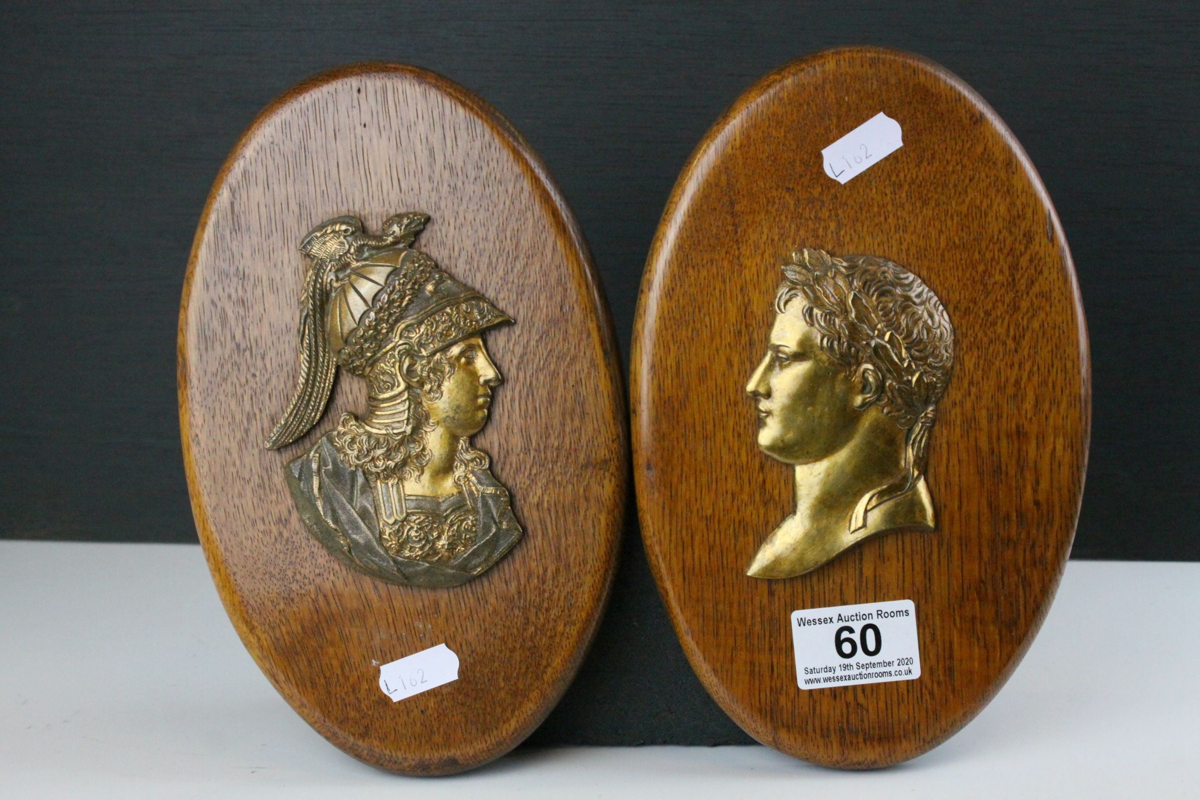 Pair of Oak Oval Wall Plaques mounted with Brass Side Profiles of Romans, 23cms high