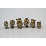 A collection of six hallmarked silver and enamel owl figures.