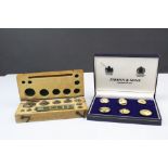 A set of brass weights in original fitted wooden case together with a set of brass buttons in a