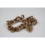 A fully hallmarked 9ct gold chain link bracelet with heart shaped padlock and safety chain.