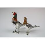 A pair of white metal and enamel cock and hen pheasant figures.