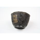An antique carved wooden Japanese Saki cup with white metal interior.