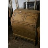 Mid 20th century Pale Oak Bureau, the fall front revealing a fitted interior, with three drawers (