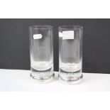 A pair of drinks glasses with fully hallmarked sterling silver bands to the base.
