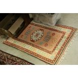 Two similar Cream and Pink Ground Rugs with stylised patterns, largest approx. 150cms x 72cms